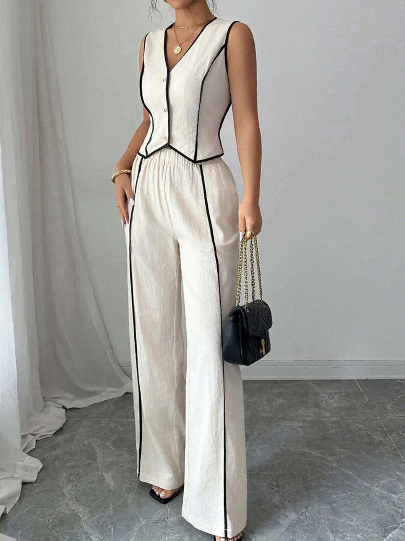 Elevate your everyday wardrobe with this contrast trim V-neck vest and pants set—a polished two-piece ensemble that blends tailored structure with relaxed ease. The sleeveless vest features a deep V-neckline and crisp contrast piping, offering a modern take on classic suiting. Buttoned detailing adds a refined touch, making it perfect for both work and weekend wear.