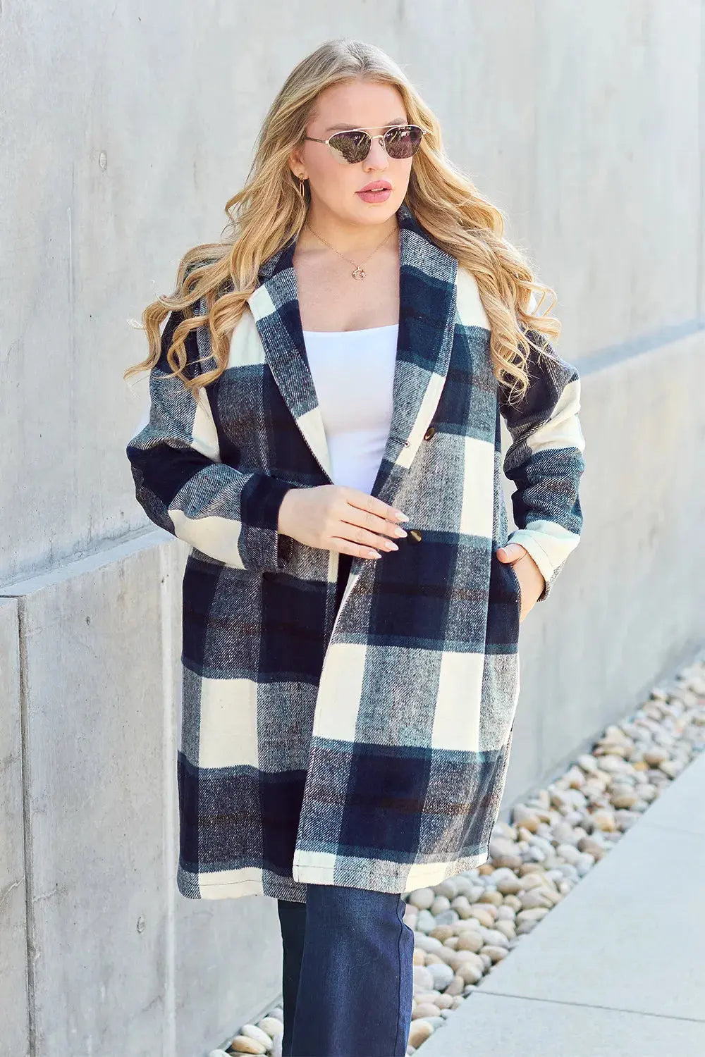 Wrap yourself in cozy charm with this Pink Plaid Button-Up Coat—a statement layer that blends warmth with playful sophistication. Designed in a soft checkered weave of blush, ivory, and brown, this midweight coat features a relaxed fit that’s perfect for layering over your everyday essentials. Classic button-front detailing and side pockets offer practicality, while the longline silhouette adds a modern, polished finish. Whether you're strolling downtown or escaping to a weekend cabin, this piece brings tex