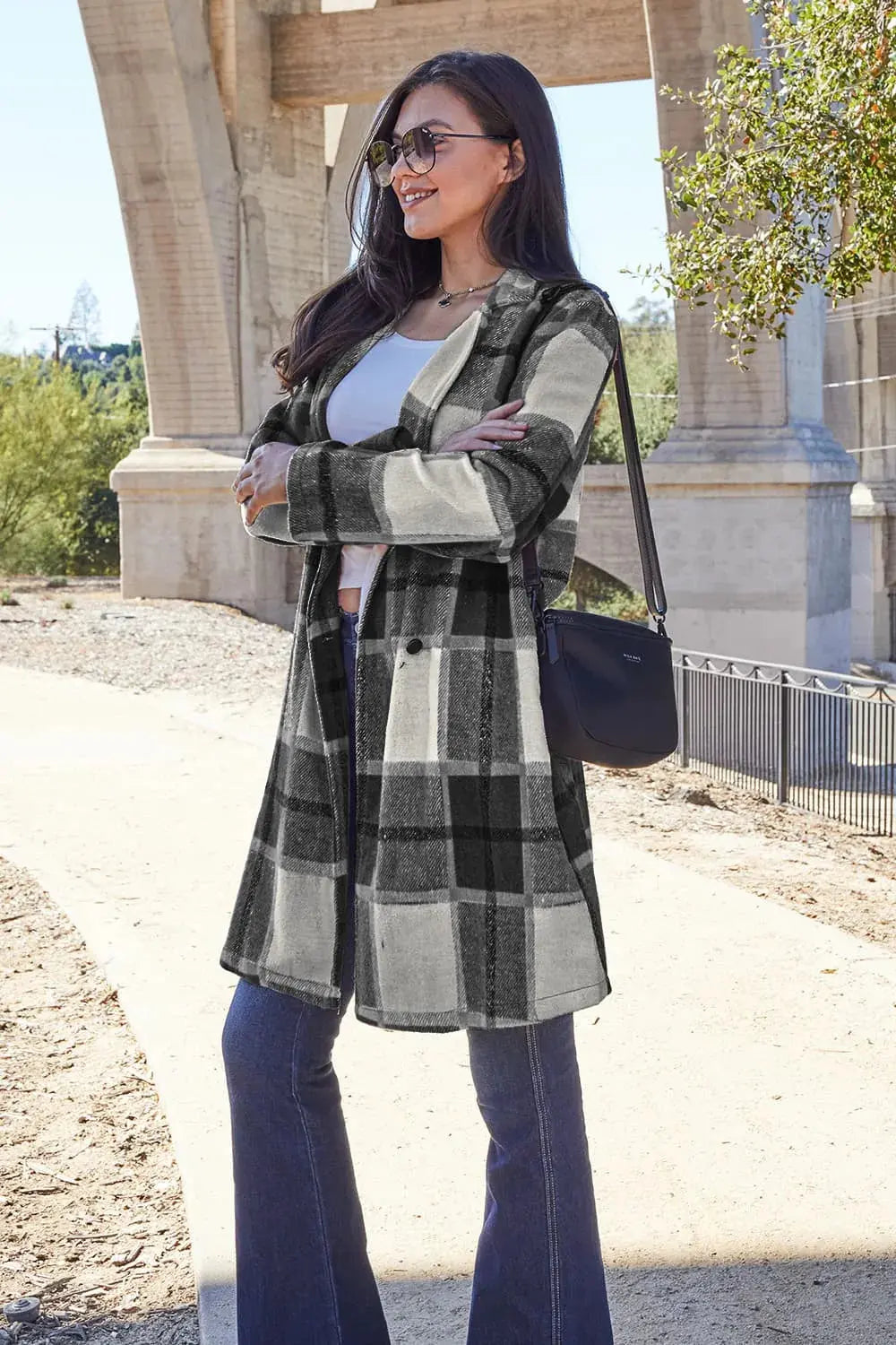 Wrap yourself in cozy charm with this Pink Plaid Button-Up Coat—a statement layer that blends warmth with playful sophistication. Designed in a soft checkered weave of blush, ivory, and brown, this midweight coat features a relaxed fit that’s perfect for layering over your everyday essentials. Classic button-front detailing and side pockets offer practicality, while the longline silhouette adds a modern, polished finish. Whether you're strolling downtown or escaping to a weekend cabin, this piece brings tex