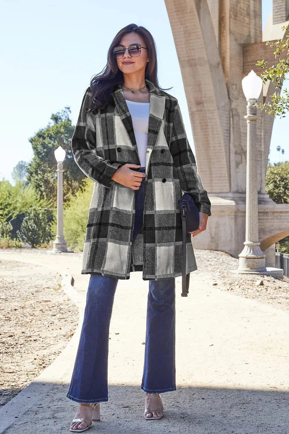 Wrap yourself in cozy charm with this Pink Plaid Button-Up Coat—a statement layer that blends warmth with playful sophistication. Designed in a soft checkered weave of blush, ivory, and brown, this midweight coat features a relaxed fit that’s perfect for layering over your everyday essentials. Classic button-front detailing and side pockets offer practicality, while the longline silhouette adds a modern, polished finish. Whether you're strolling downtown or escaping to a weekend cabin, this piece brings tex