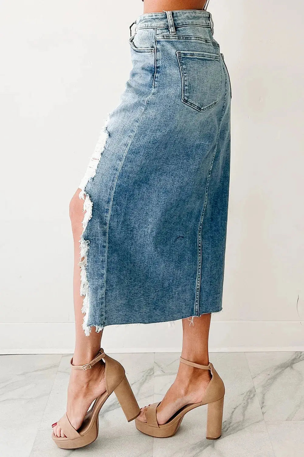 Made from a blend of 93% cotton, 5% polyester, and 2% elastane, it holds its shape without stretch, ensuring structure and a tailored feel. Product measurements across S–XL range from a 26.4" to 34.3" waist, and 35.4" to 43.3" hips, giving it broad versatility. The button closure, traditional pockets, and asymmetrical cut give it a lived-in aesthetic with elevated attitude.