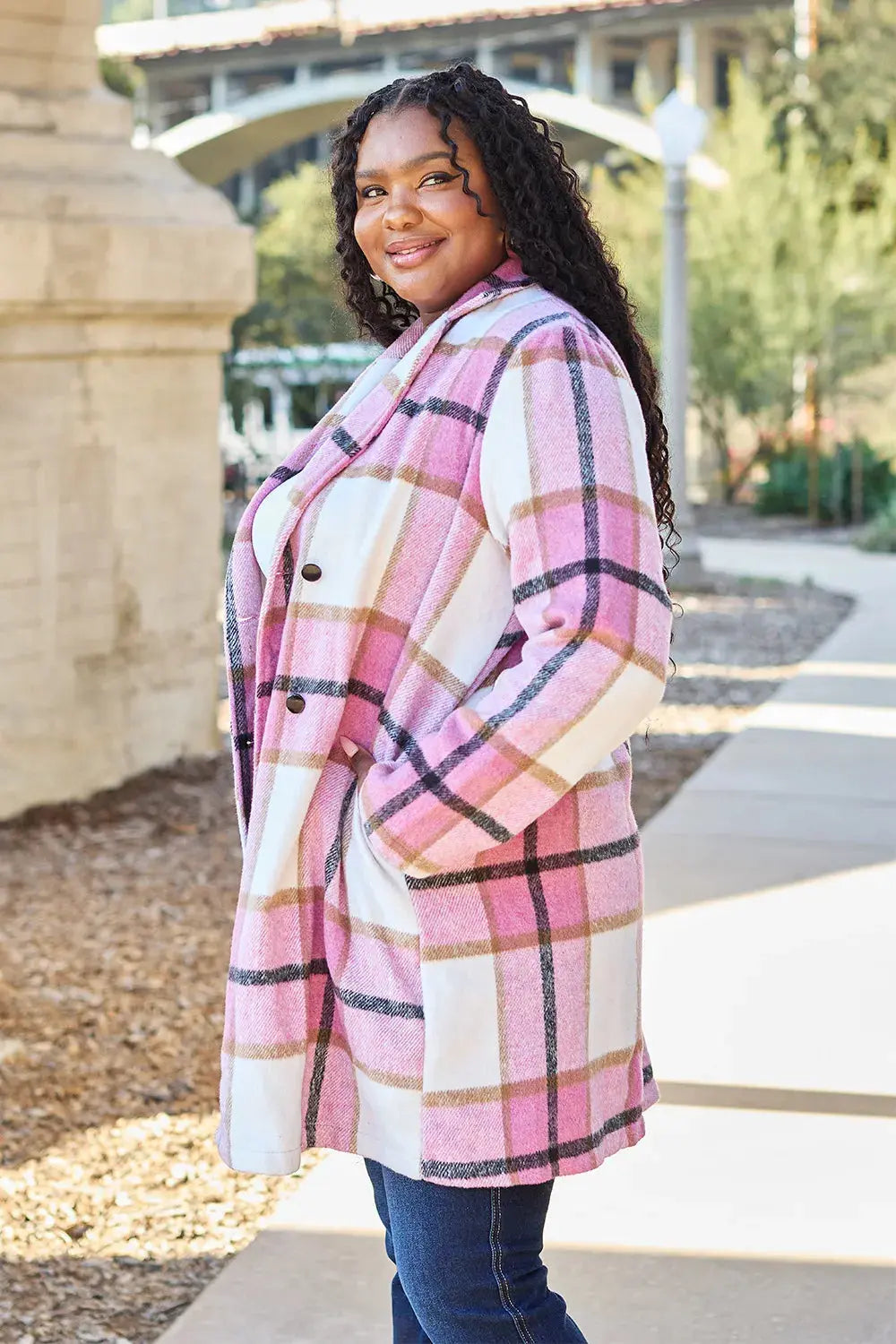 Wrap yourself in cozy charm with this Pink Plaid Button-Up Coat—a statement layer that blends warmth with playful sophistication. Designed in a soft checkered weave of blush, ivory, and brown, this midweight coat features a relaxed fit that’s perfect for layering over your everyday essentials. Classic button-front detailing and side pockets offer practicality, while the longline silhouette adds a modern, polished finish. Whether you're strolling downtown or escaping to a weekend cabin, this piece brings tex