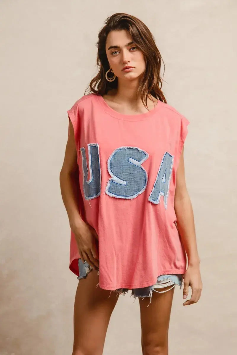 This fashion USA graphic t-shirt features a vibrant coral pink base with bold denim-style USA lettering across the chest. Made from soft cotton blend fabric for ultimate comfort and breathability. The relaxed oversized fit provides a casual, effortless look perfect for everyday wear. The vintage-inspired patriotic design makes it ideal for summer festivals, casual outings, or showing American pride. The round neckline and loose silhouette offer versatile styling options for pairing with jeans, shorts, etc.