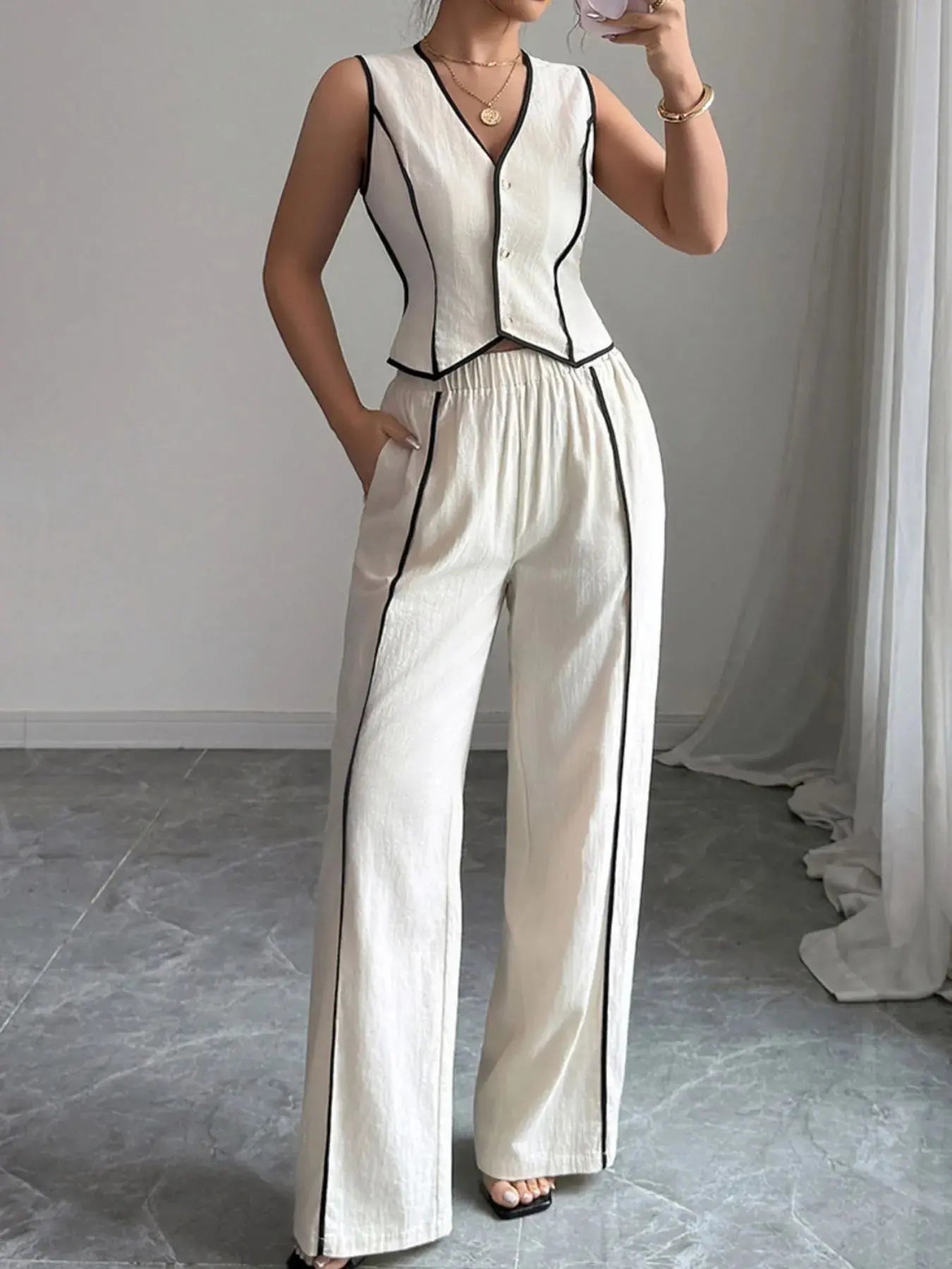 Elevate your everyday wardrobe with this contrast trim V-neck vest and pants set—a polished two-piece ensemble that blends tailored structure with relaxed ease. The sleeveless vest features a deep V-neckline and crisp contrast piping, offering a modern take on classic suiting. Buttoned detailing adds a refined touch, making it perfect for both work and weekend wear.