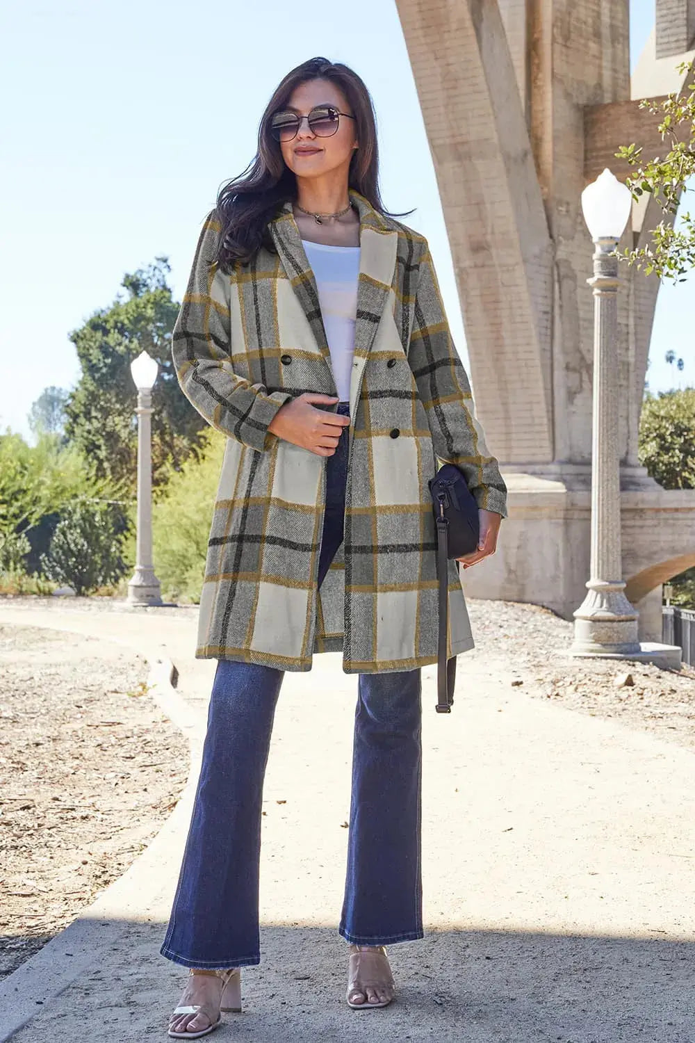Wrap yourself in cozy charm with this Pink Plaid Button-Up Coat—a statement layer that blends warmth with playful sophistication. Designed in a soft checkered weave of blush, ivory, and brown, this midweight coat features a relaxed fit that’s perfect for layering over your everyday essentials. Classic button-front detailing and side pockets offer practicality, while the longline silhouette adds a modern, polished finish. Whether you're strolling downtown or escaping to a weekend cabin, this piece brings tex