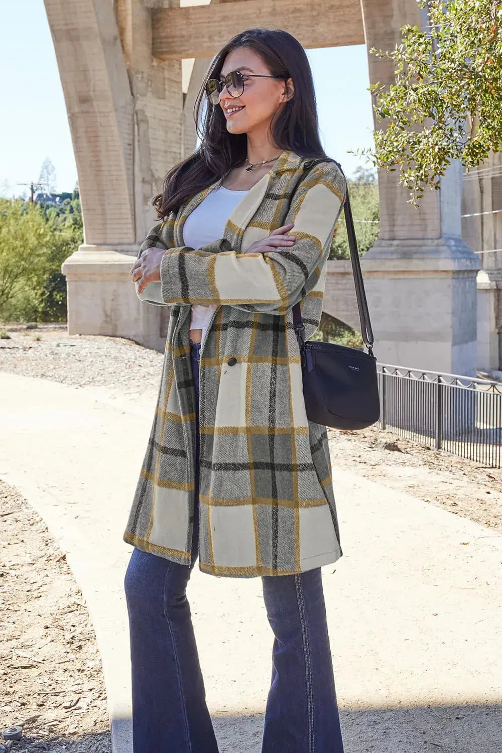 Wrap yourself in cozy charm with this Pink Plaid Button-Up Coat—a statement layer that blends warmth with playful sophistication. Designed in a soft checkered weave of blush, ivory, and brown, this midweight coat features a relaxed fit that’s perfect for layering over your everyday essentials. Classic button-front detailing and side pockets offer practicality, while the longline silhouette adds a modern, polished finish. Whether you're strolling downtown or escaping to a weekend cabin, this piece brings tex