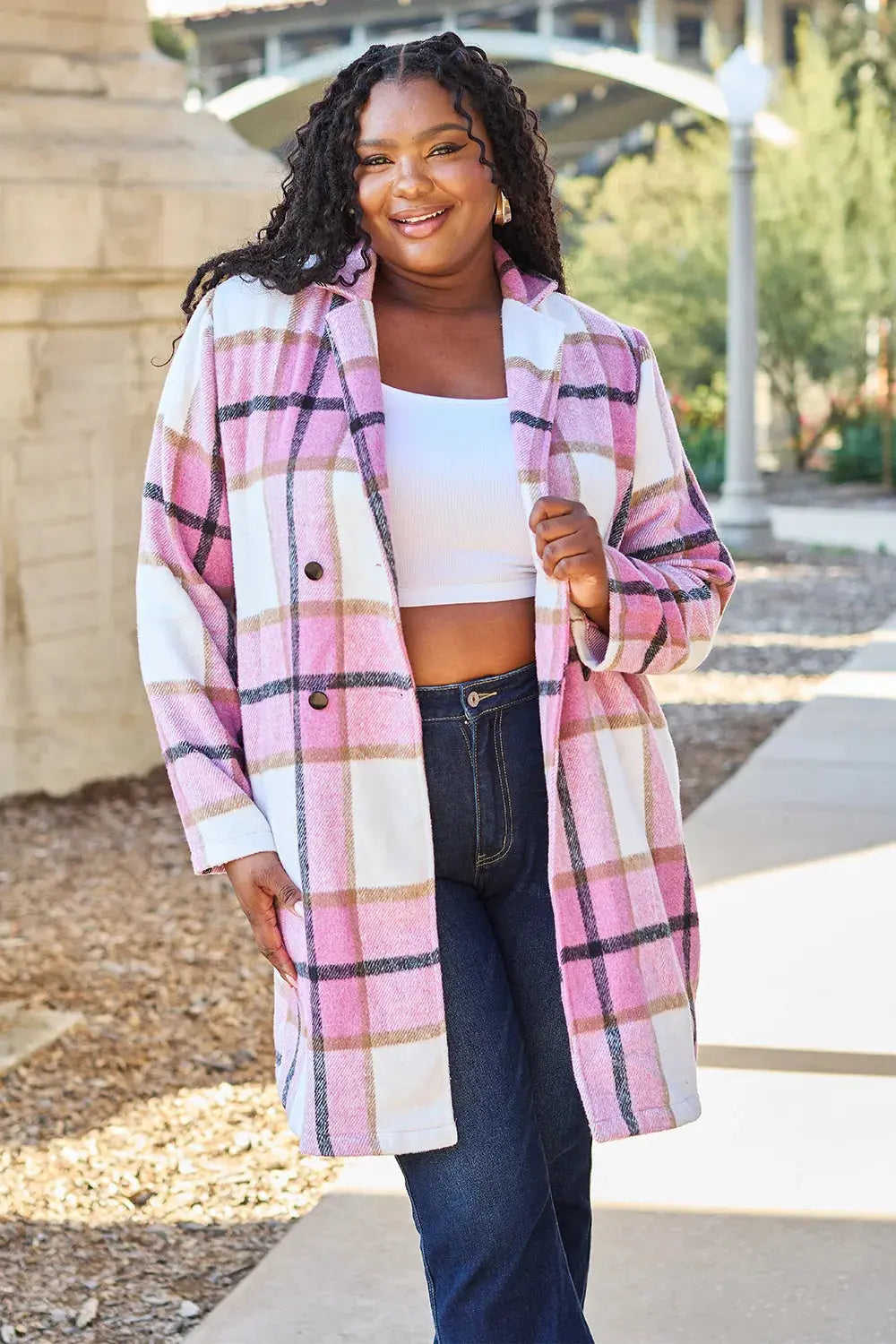 Wrap yourself in cozy charm with this Pink Plaid Button-Up Coat—a statement layer that blends warmth with playful sophistication. Designed in a soft checkered weave of blush, ivory, and brown, this midweight coat features a relaxed fit that’s perfect for layering over your everyday essentials. Classic button-front detailing and side pockets offer practicality, while the longline silhouette adds a modern, polished finish. Whether you're strolling downtown or escaping to a weekend cabin, this piece brings tex