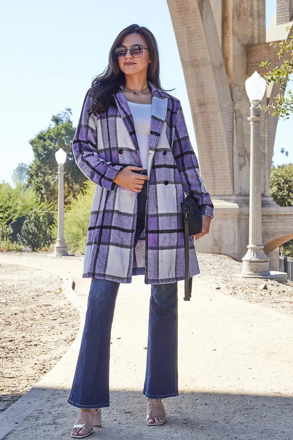 Wrap yourself in cozy charm with this Pink Plaid Button-Up Coat—a statement layer that blends warmth with playful sophistication. Designed in a soft checkered weave of blush, ivory, and brown, this midweight coat features a relaxed fit that’s perfect for layering over your everyday essentials. Classic button-front detailing and side pockets offer practicality, while the longline silhouette adds a modern, polished finish. Whether you're strolling downtown or escaping to a weekend cabin, this piece brings tex