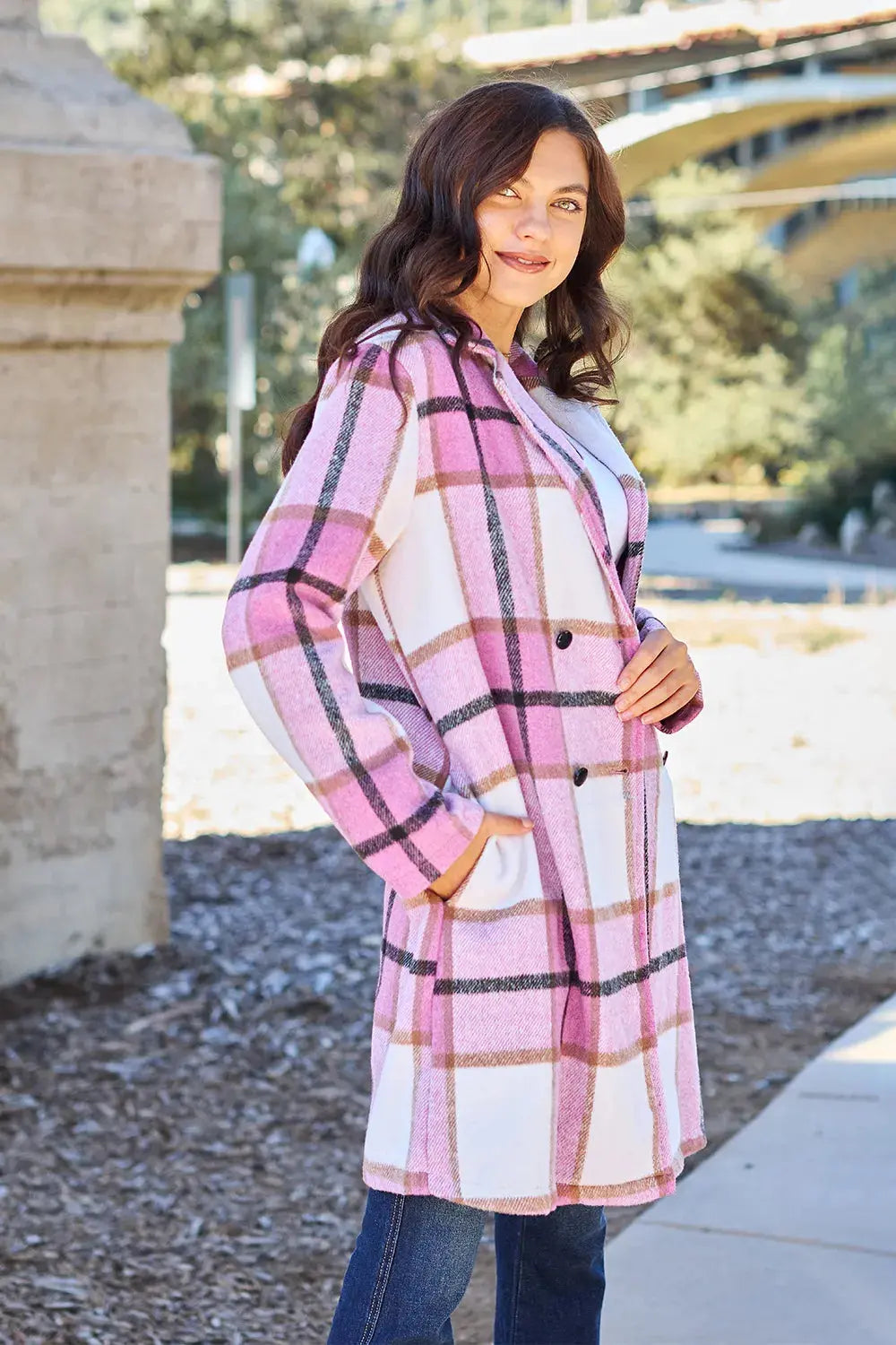 Wrap yourself in cozy charm with this Pink Plaid Button-Up Coat—a statement layer that blends warmth with playful sophistication. Designed in a soft checkered weave of blush, ivory, and brown, this midweight coat features a relaxed fit that’s perfect for layering over your everyday essentials. Classic button-front detailing and side pockets offer practicality, while the longline silhouette adds a modern, polished finish. Whether you're strolling downtown or escaping to a weekend cabin, this piece brings tex