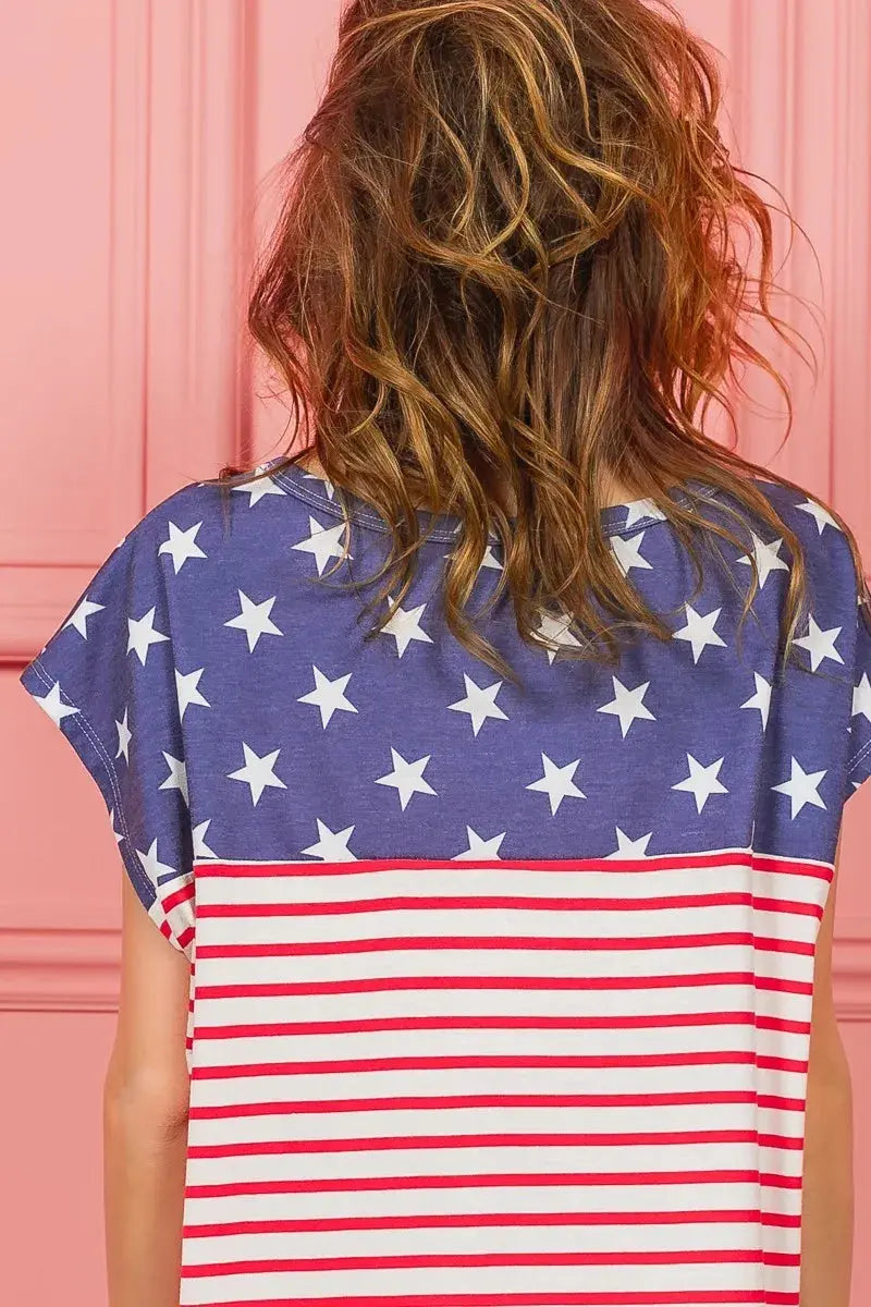 A back view of a person wearing a t-shirt with American flag design against a pink background.