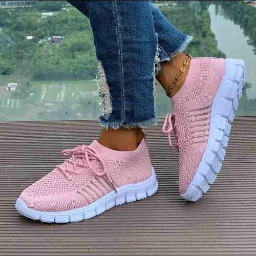 Model wearing a pink pair of the Breathable Mesh Round Toe Sneakers