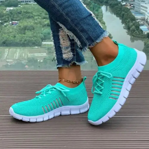 Model wearing a teal pair of the Breathable Mesh Round Toe Sneakers