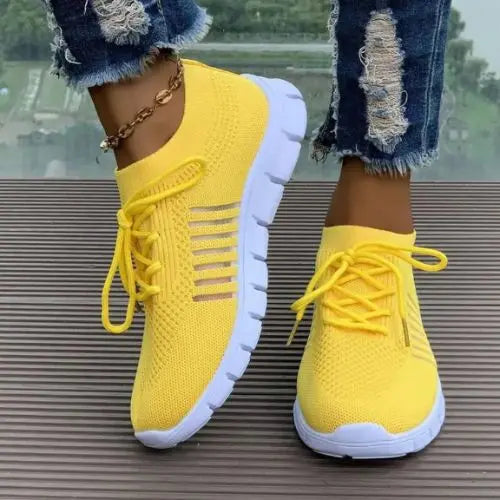 Model wearing yellow pair of the Breathable Mesh Round Toe Sneakers