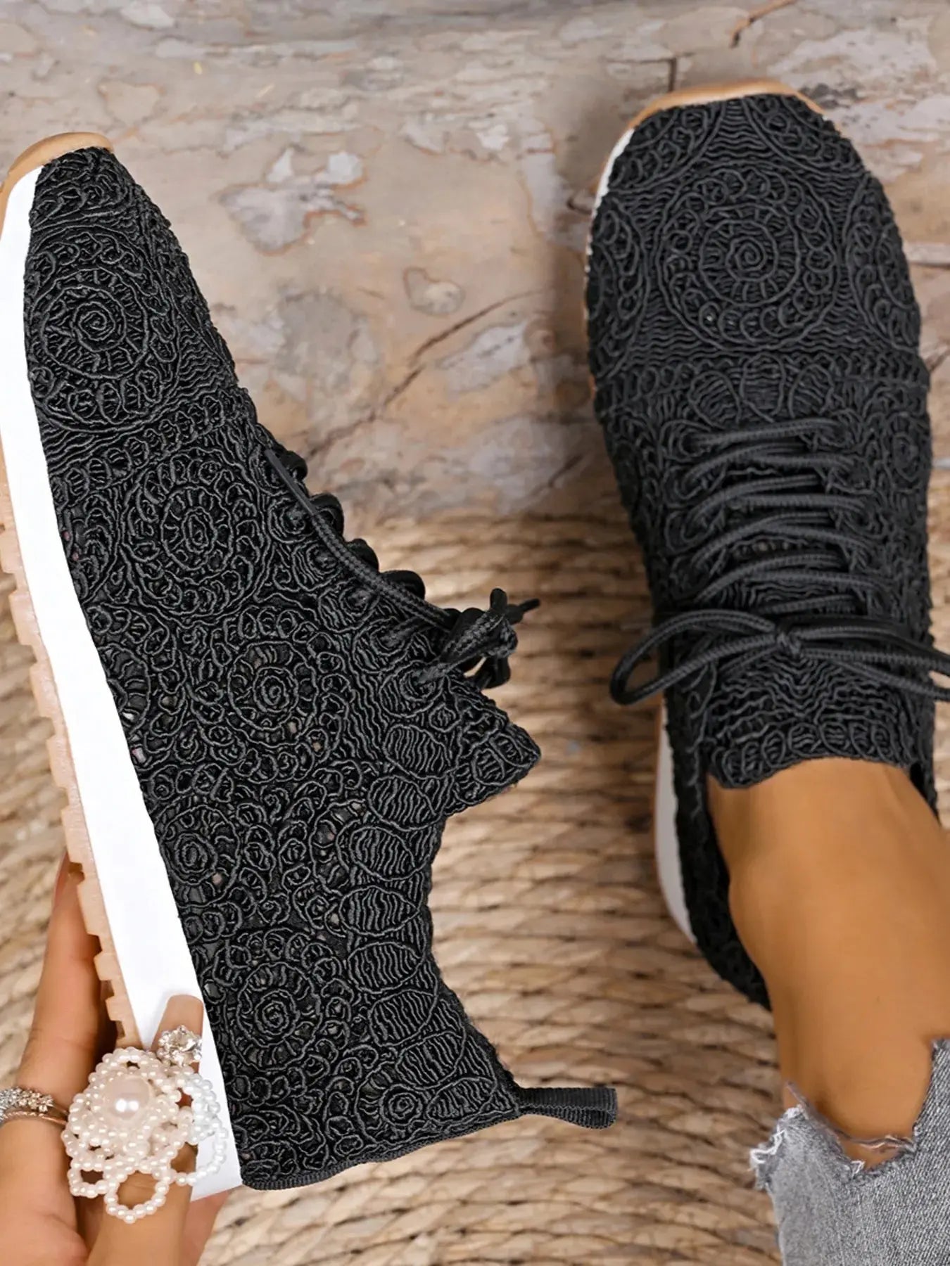 Black textured sneakers on a stone surface