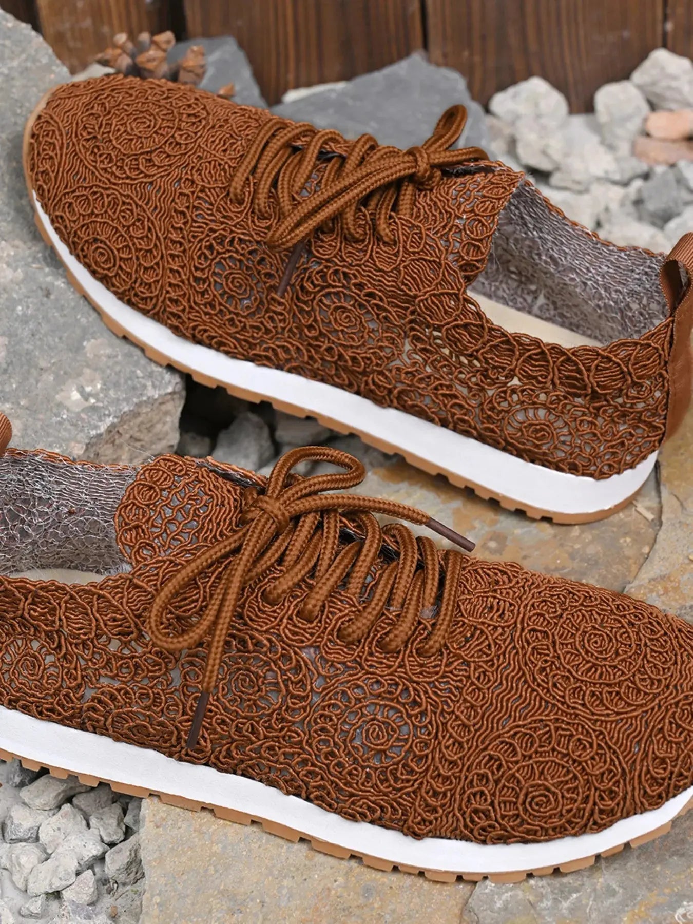 Brown patterned sneakers on a stone surface