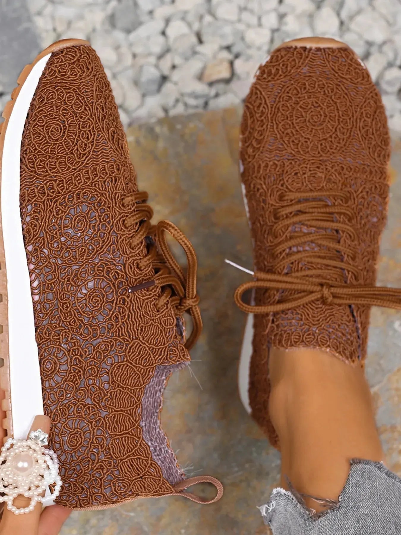 Brown patterned shoes on a stone surface