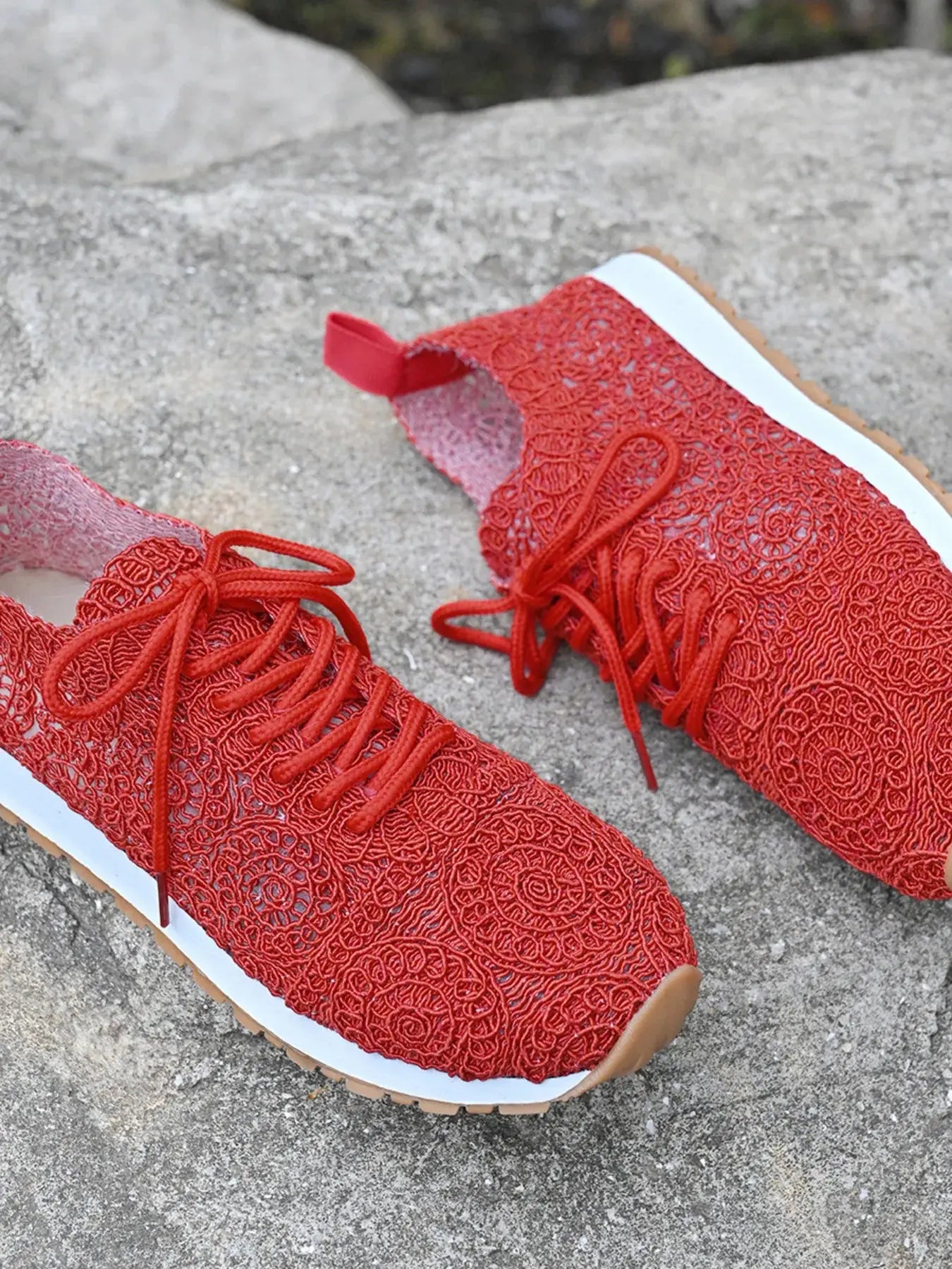 Red lace-up shoes on a concrete surface