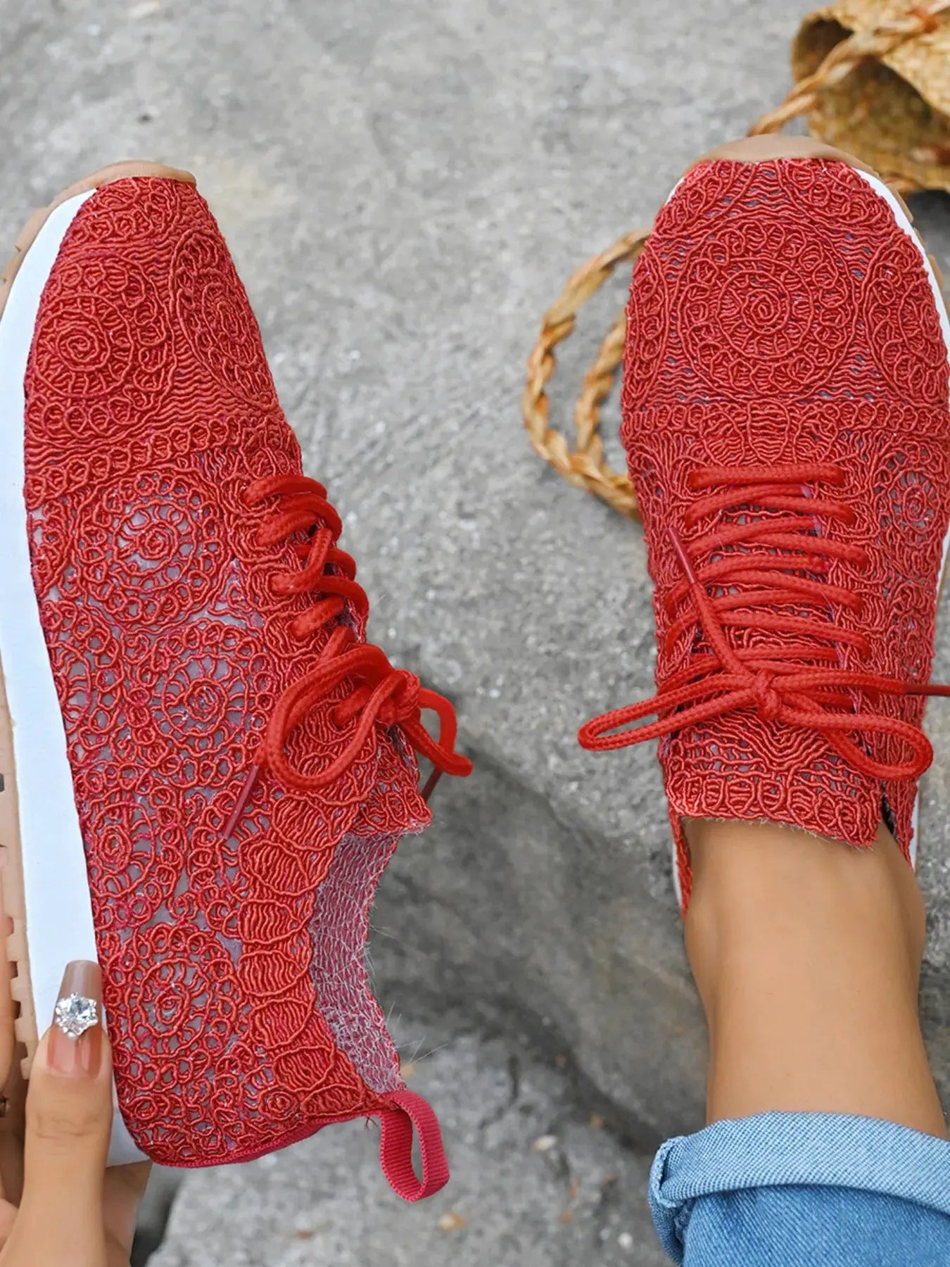 Red lace-up shoes on a gray pavement