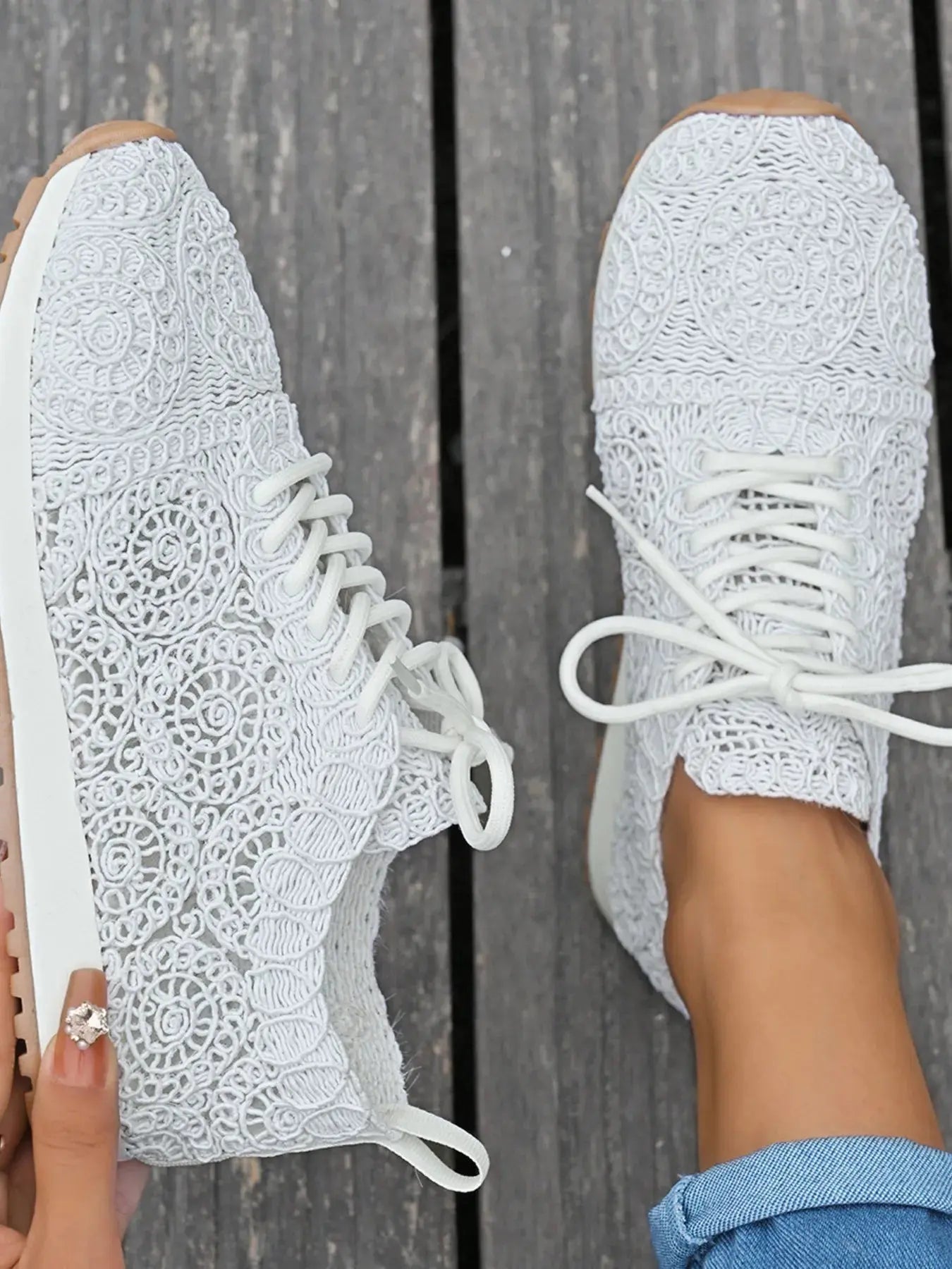 White lace-up sneakers with a wooden floor background