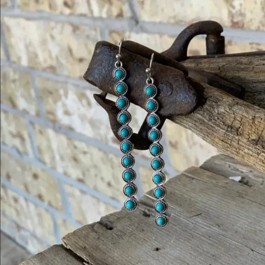 Turquoise stone dangle earrings in silver frame with linear drop design — western-inspired jewelry from Atlas by J&D.