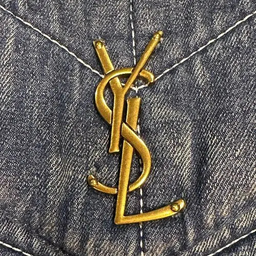 Gold Yves Saint Laurent logo on denim fabric