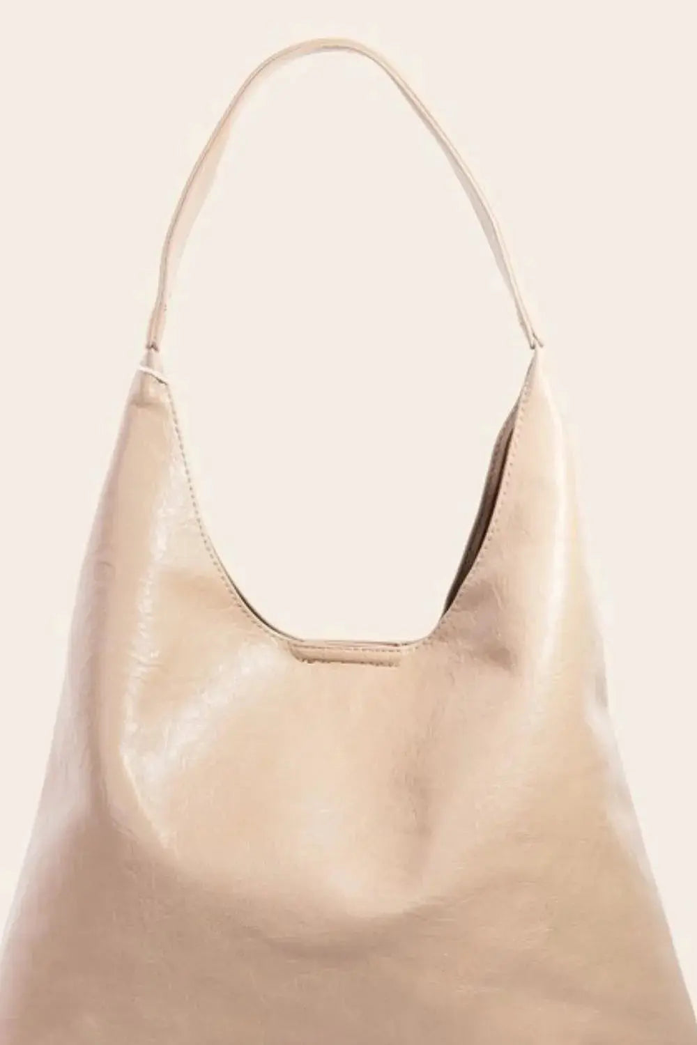A closer shot of a beige faux leather shoulder bag with a handle.