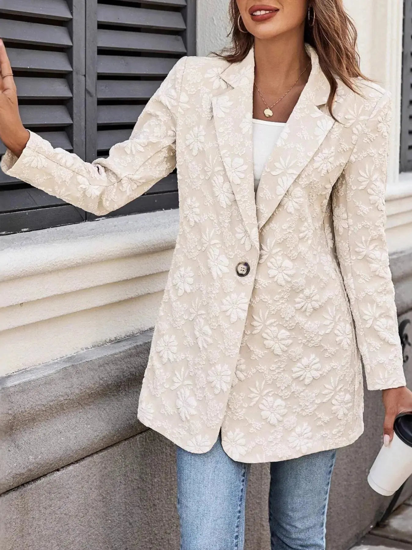 Woman wearing a beige floral blazer outdoors