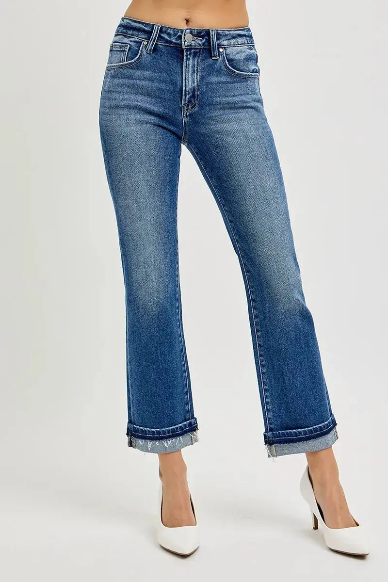 Cuffed Blue jeans worn by a person on a white background