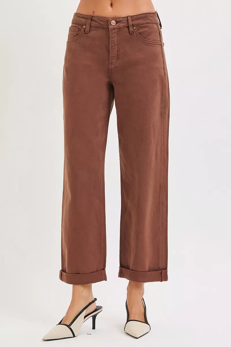 Brown jeans worn by a person on a white background