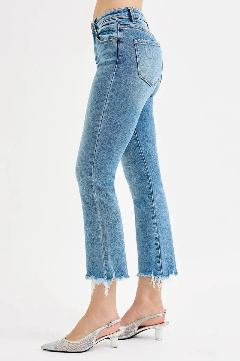 Light blue jeans on a person wearing white sling back shoes with a white background,