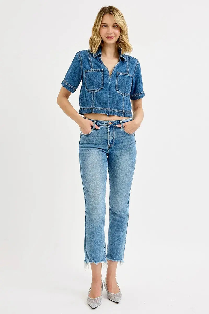 Woman wearing a denim top and jeans on a white background.