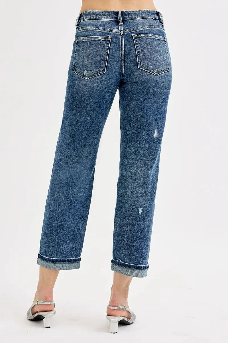 A person with their back to the camera wearing cropped blue jeans.