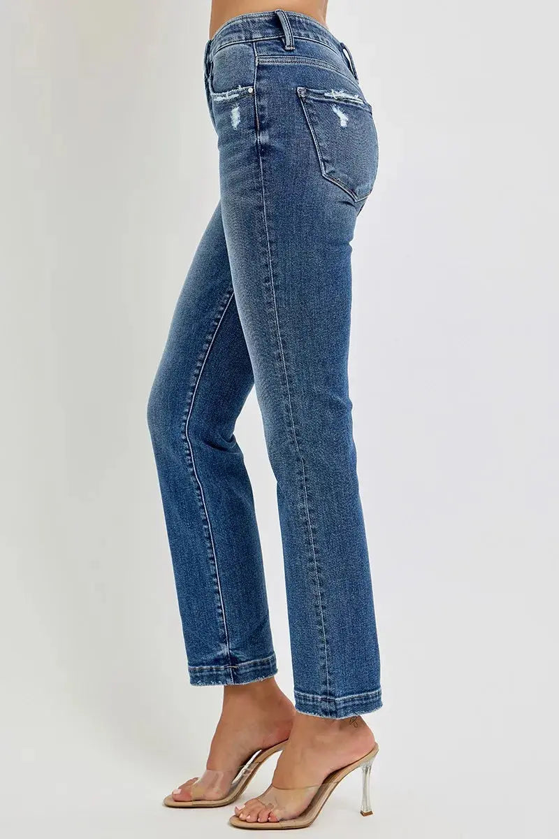 A side view of cropped blue jeans worn by a person on a white background