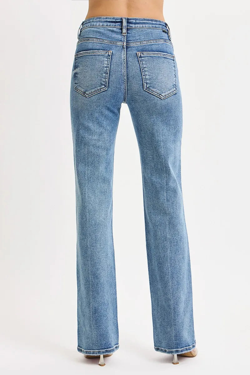 The back of a person wearing straight leg blue jeans on a white background