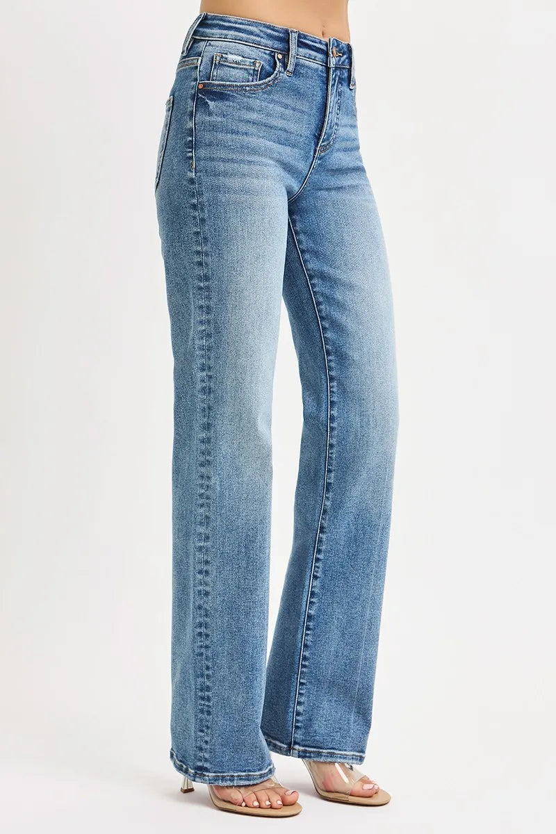 Side view of straight leg blue jeans on a white background