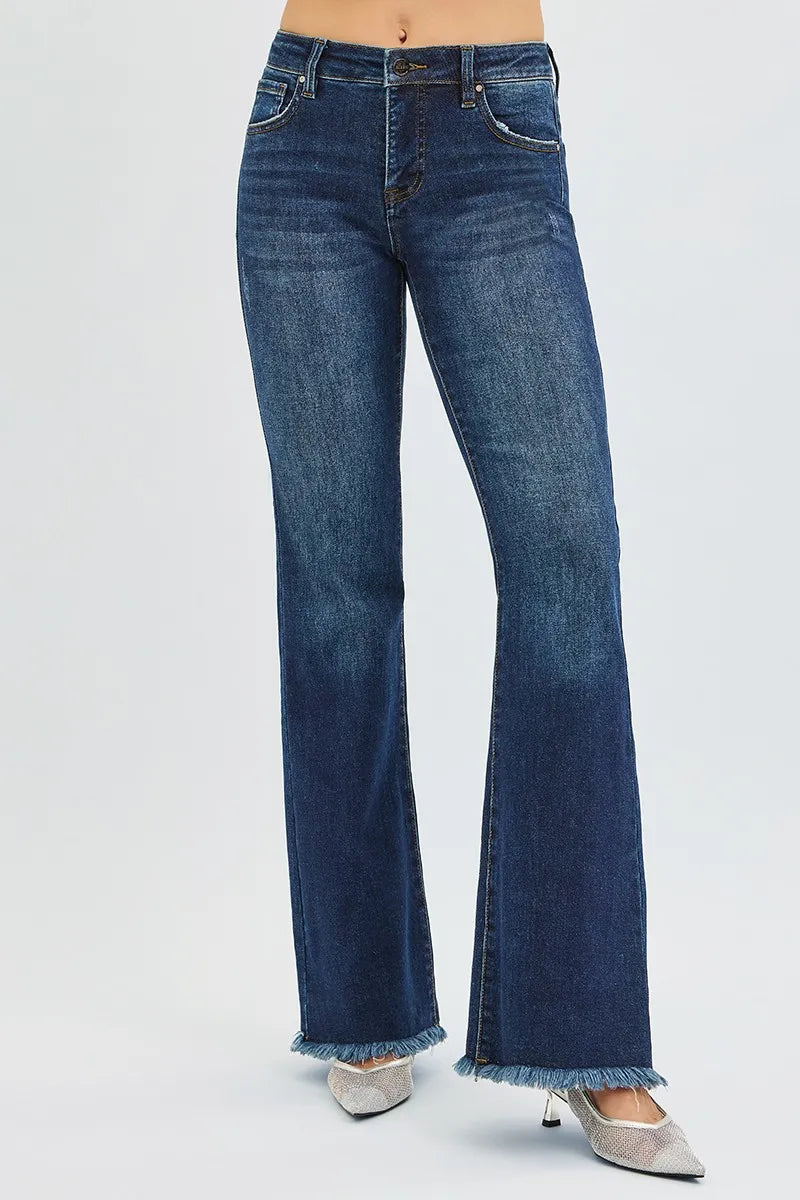 Dark blue jeans with a raw frayed hem on a white background
