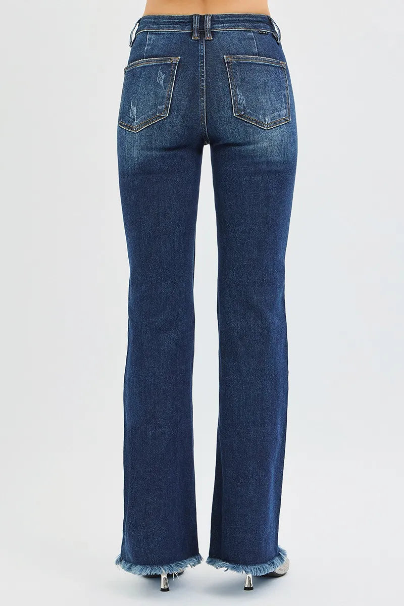 The back of dark wash blue jeans with frayed cuffs on a white background