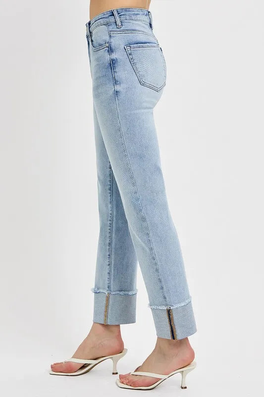 The side view of light blue jeans worn by a person on a white background