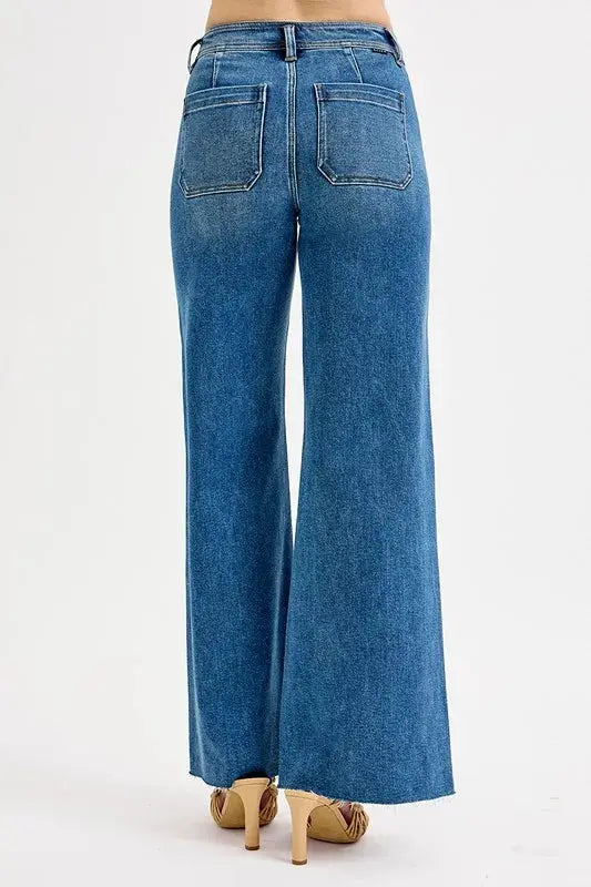 The back of wide leg blue jeans worn by a person on a white background
