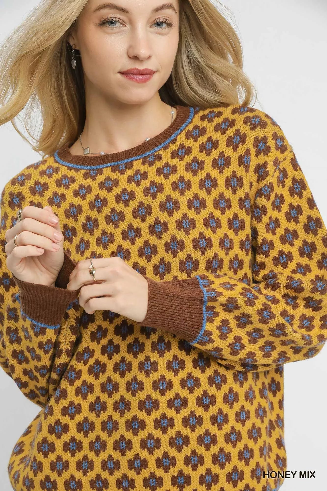 Woman wearing a patterned sweater with a white background