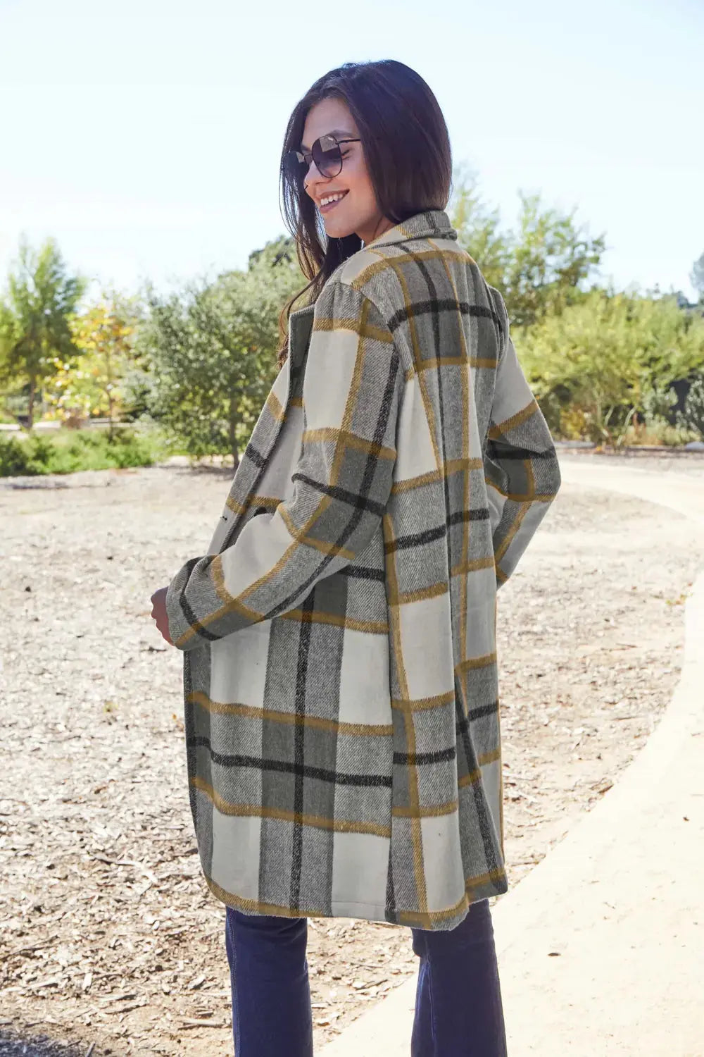 Wrap yourself in cozy charm with this Pink Plaid Button-Up Coat—a statement layer that blends warmth with playful sophistication. Designed in a soft checkered weave of blush, ivory, and brown, this midweight coat features a relaxed fit that’s perfect for layering over your everyday essentials. Classic button-front detailing and side pockets offer practicality, while the longline silhouette adds a modern, polished finish. Whether you're strolling downtown or escaping to a weekend cabin, this piece brings tex