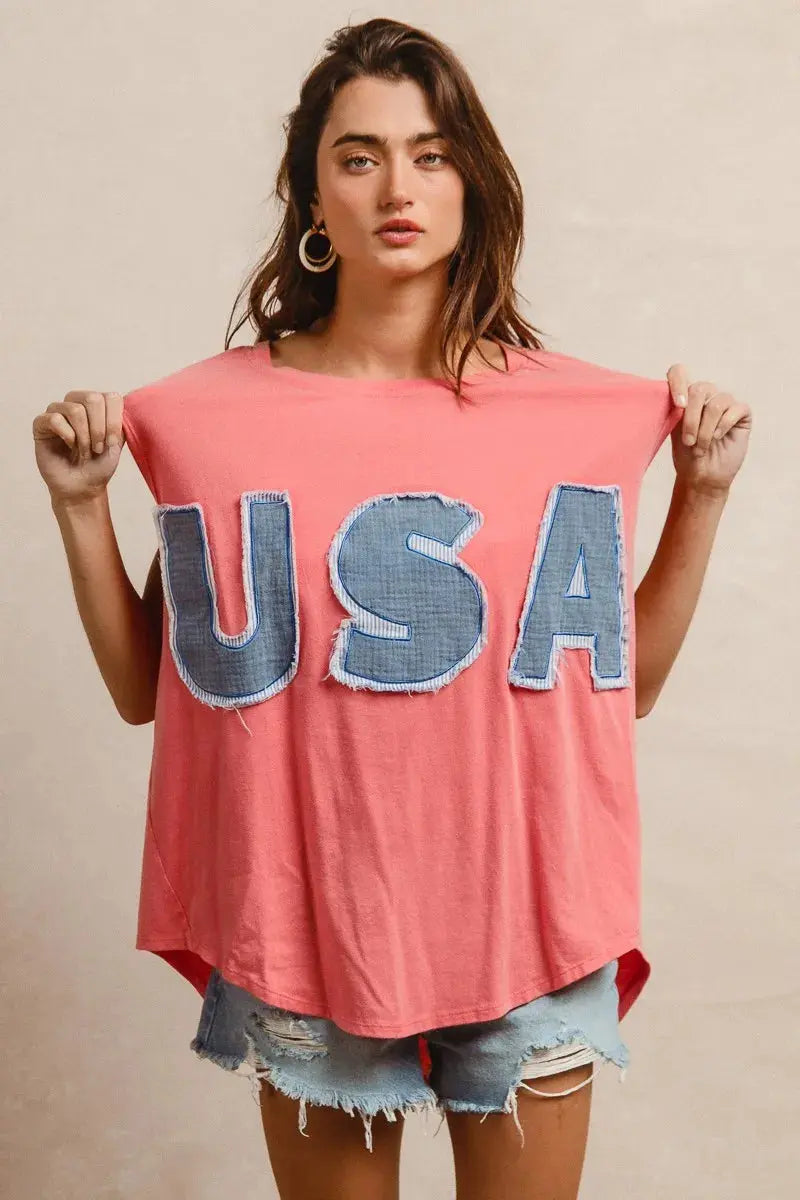 This fashion USA graphic t-shirt features a vibrant coral pink base with bold denim-style USA lettering across the chest. Made from soft cotton blend fabric for ultimate comfort and breathability. The relaxed oversized fit provides a casual, effortless look perfect for everyday wear. The vintage-inspired patriotic design makes it ideal for summer festivals, casual outings, or showing American pride. The round neckline and loose silhouette offer versatile styling options for pairing with jeans, shorts, etc.