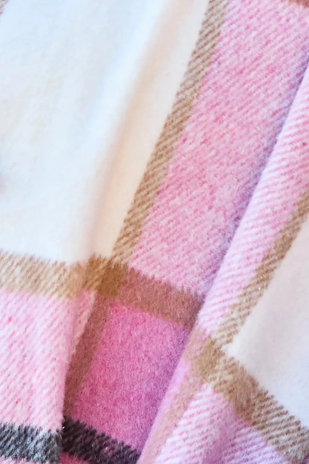 Wrap yourself in cozy charm with this Pink Plaid Button-Up Coat—a statement layer that blends warmth with playful sophistication. Designed in a soft checkered weave of blush, ivory, and brown, this midweight coat features a relaxed fit that’s perfect for layering over your everyday essentials. Classic button-front detailing and side pockets offer practicality, while the longline silhouette adds a modern, polished finish. Whether you're strolling downtown or escaping to a weekend cabin, this piece brings tex