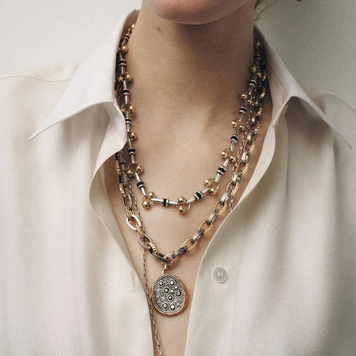 Crafted from 18K gold-plated stainless steel, these necklaces resist corrosion and tarnish with proper care. Ranging from 13.8" to 15.7" in length and fitted with extension chains, the set adjusts comfortably at the collarbone, layering easily with open necklines. Avoid moisture and strenuous activity to preserve the gold finish over time.