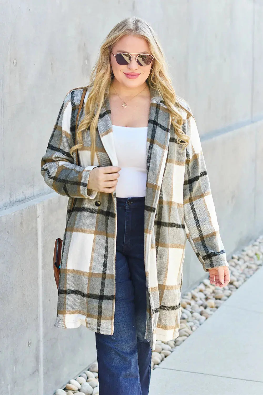 Wrap yourself in cozy charm with this Pink Plaid Button-Up Coat—a statement layer that blends warmth with playful sophistication. Designed in a soft checkered weave of blush, ivory, and brown, this midweight coat features a relaxed fit that’s perfect for layering over your everyday essentials. Classic button-front detailing and side pockets offer practicality, while the longline silhouette adds a modern, polished finish. Whether you're strolling downtown or escaping to a weekend cabin, this piece brings tex
