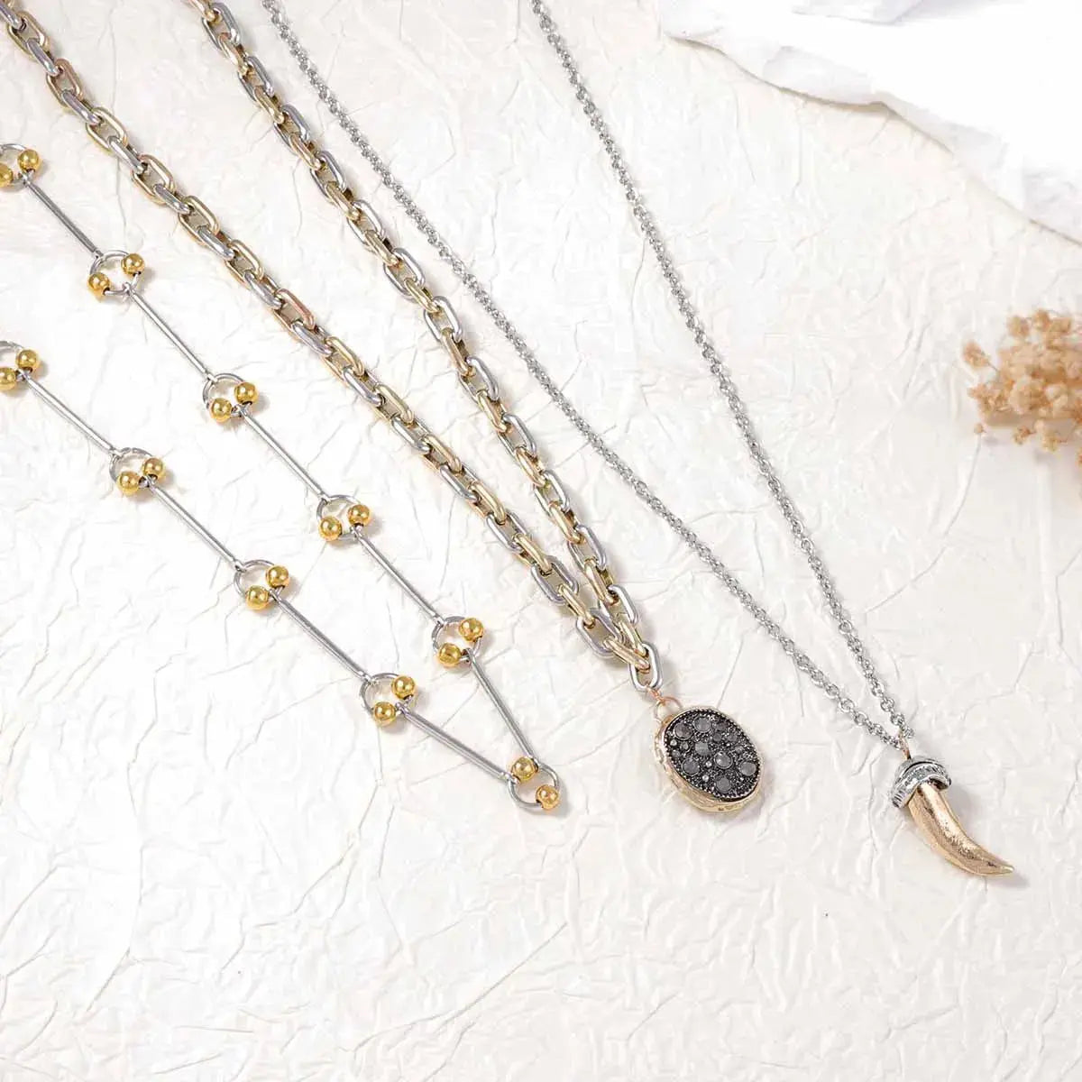 Crafted from 18K gold-plated stainless steel, these necklaces resist corrosion and tarnish with proper care. Ranging from 13.8" to 15.7" in length and fitted with extension chains, the set adjusts comfortably at the collarbone, layering easily with open necklines. Avoid moisture and strenuous activity to preserve the gold finish over time.
