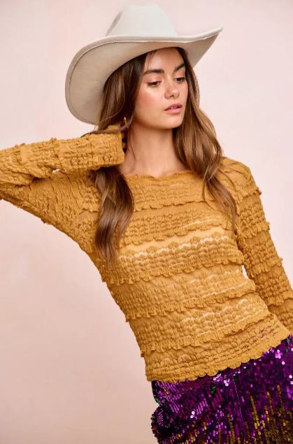 Mustard textured long sleeve top in a warm-toned hue styled with a sequin skirt for a standout seasonal outfit.