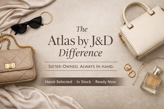 Flat lay of designer-inspired handbags, jewelry, and accessories styled on a neutral background for Atlas by J&D, a sister-owned pop-up boutique with in-stock items.