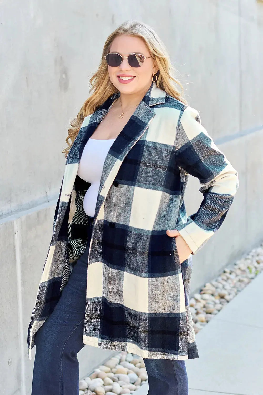 Wrap yourself in cozy charm with this Pink Plaid Button-Up Coat—a statement layer that blends warmth with playful sophistication. Designed in a soft checkered weave of blush, ivory, and brown, this midweight coat features a relaxed fit that’s perfect for layering over your everyday essentials. Classic button-front detailing and side pockets offer practicality, while the longline silhouette adds a modern, polished finish. Whether you're strolling downtown or escaping to a weekend cabin, this piece brings tex