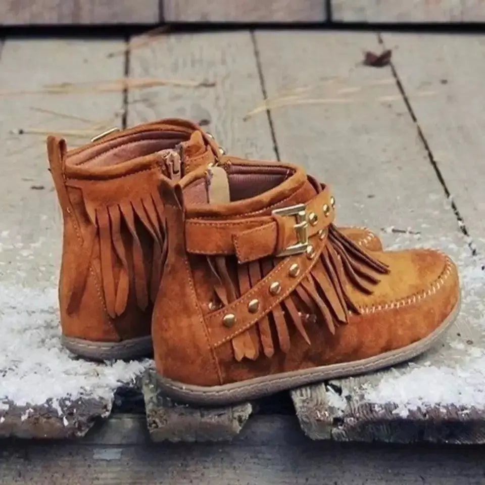 Earthy Tones set the tone for effortless style in these studded fringe suede flat boots by Grace Step. Designed to feel like a second skin, the vegan suede contours gently to your foot, creating a balanced mix of grounded elegance and playful charm. Whether dressing up denim or offsetting a neutral maxi dress, this boot adds instant personality to any look.
